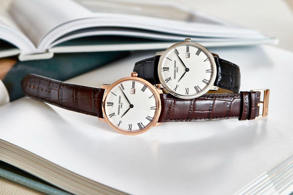 Two Frederique Constant Slimline watches placed on an open book